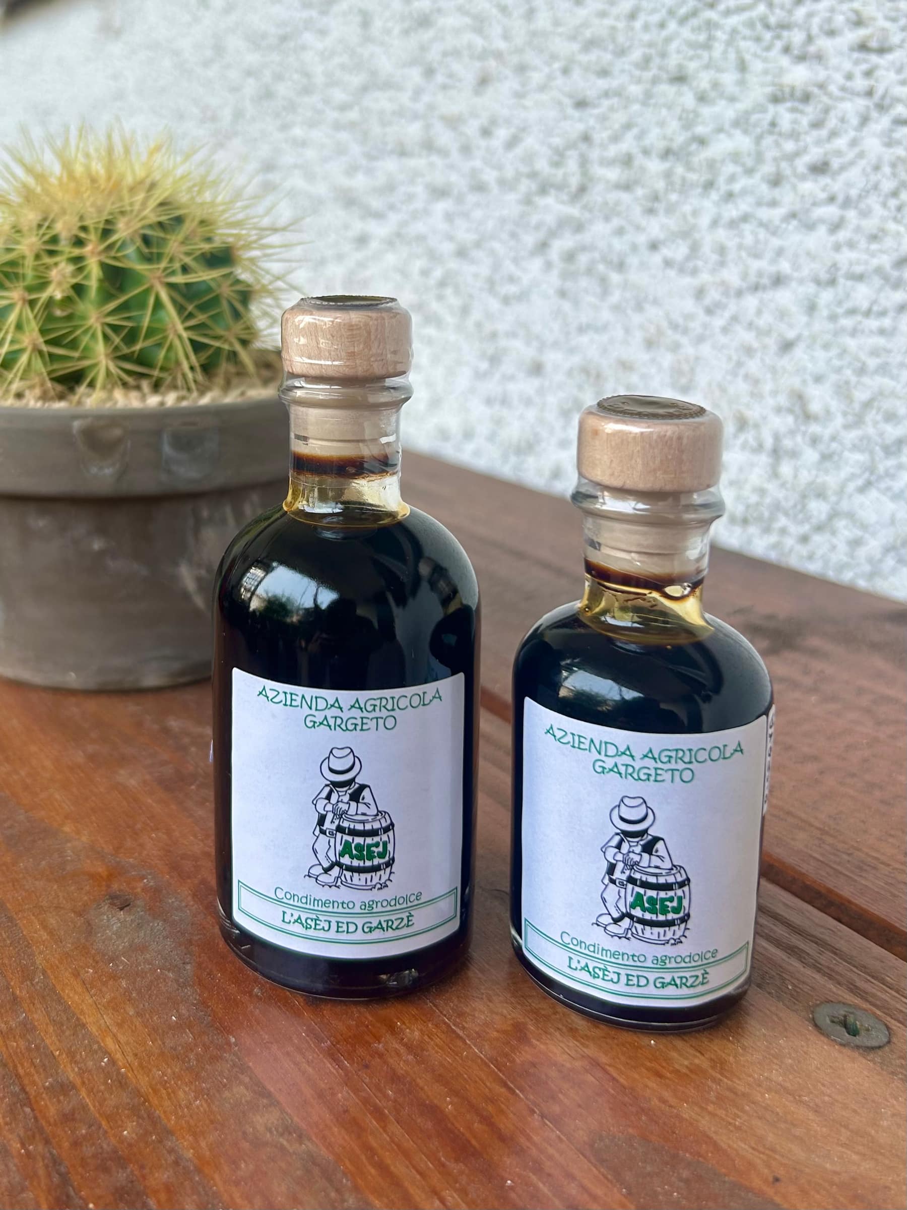 Le due bottiglie della Riserva, da 50 e da 100 ml, con etichetta bianca e tappo di sughero